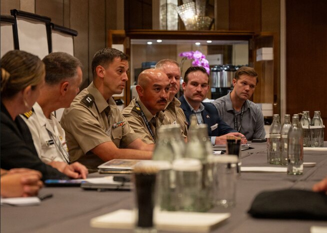 Maj. Luis Torres, National Guard Bureau liaison officer to U.S. Indo-Pacific Command, or INDOPACOM, and Capt. Matthew Chartier, operations officer, 420th Chemical Battalion, 96th Troop Command, talk with others at the Indo-Pacific Health Security Summit, June 7, 2026, in Kuala Lumpur, Malaysia.