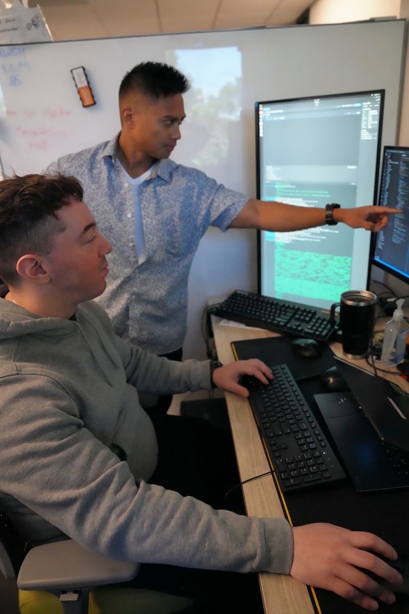photo of two men looking at computer screens