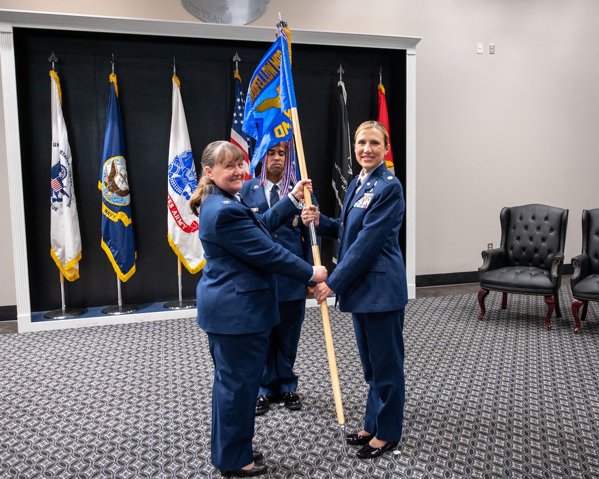 U.S. Air Force Col. La Rita Abel, left, Goodfellow Medical Group commander, passes the Goodfellow Operational Medical Readiness Squadron guidon to Lt Col. Tonya Toche-Howard, right, incoming GOMRS commander, during an assumption of command ceremony at Goodfellow Air Force Base, Texas, June 17, 2026. The passing of the guidon to Toche-Howard signifies her taking command of the GOMRS. (U.S. Air Force photo by Staff Sgt. Nathan Call)