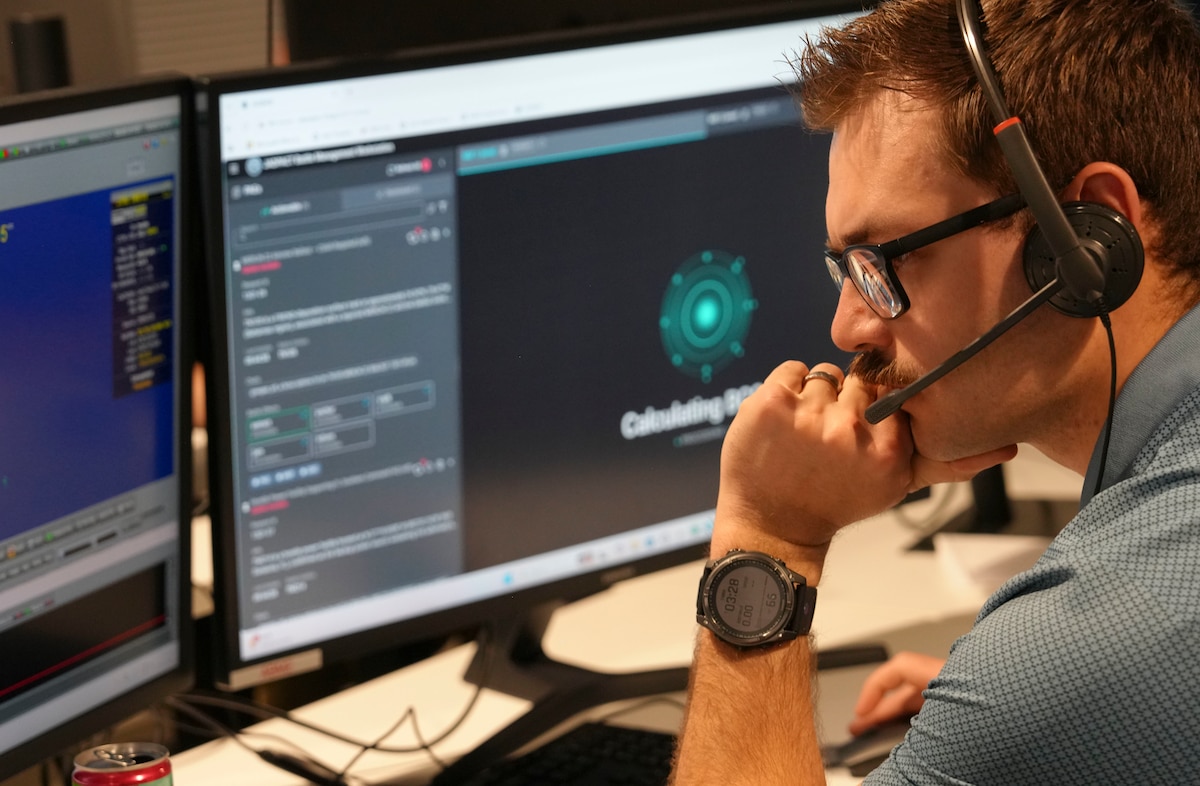 photo of a person wearing a headset working at a computer