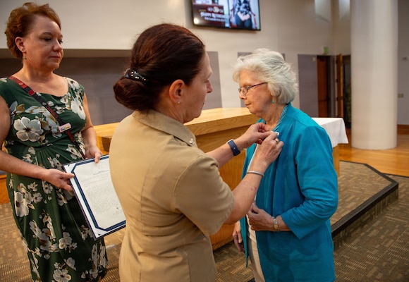 U.S. Navy Capt. Elizabeth Adriano, director of Naval Medical Center San Diego (NMCSD), presents Carol Devine, executive assistant to the executive officer at NMCSD, with the Civilian Career Service Award during Devine’s retirement ceremony at NMCSD, June 24, 2026. Devine retired after 59 years of federal service, including 49 years at NMCSD. Throughout her career, Devine provided steadfast administrative leadership and continuity to generations of military and civilian leaders. The mission of NMCSD is to optimize health and enhance readiness. NMCSD employs more than 5,500 active-duty military personnel, civilians, and contractors in southern California to deliver exceptional care afloat and ashore. (U.S. Navy photo by Mass Communication Specialist 1st Class Marcus Stanley)