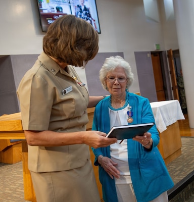 U.S. Navy Capt. Cindi Palacios, executive officerr of Naval Medical Center San Diego (NMCSD), presents a retirement memento to Carol Devine, executive assistant to the executive officer, during Devine’s retirement ceremony at NMCSD, June 24, 2026. Devine retired after 59 years of federal service, including 49 years at NMCSD. Throughout her career, Devine provided steadfast administrative leadership and continuity to generations of military and civilian leaders. The mission of NMCSD is to optimize health and enhance readiness. NMCSD employs more than 5,500 active-duty military personnel, civilians, and contractors in southern California to deliver exceptional care afloat and ashore. (U.S. Navy photo by Mass Communication Specialist 1st Class Marcus Stanley)