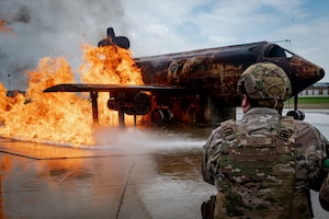 U.S. Air Force Staff Sergeant Rick Romero, pl-1 area supervisor, 5th Security Force squadron, puts out a fire as a part of burn training during the bivouac exercise at Fargo Air National Guard Base, North Dakota, June 1st, 2026. Air Force burn training consists of specialized live-fire exercises conducted by Fire Protection Specialists to handle aircraft crashes, structural fires, and wildland emergencies.