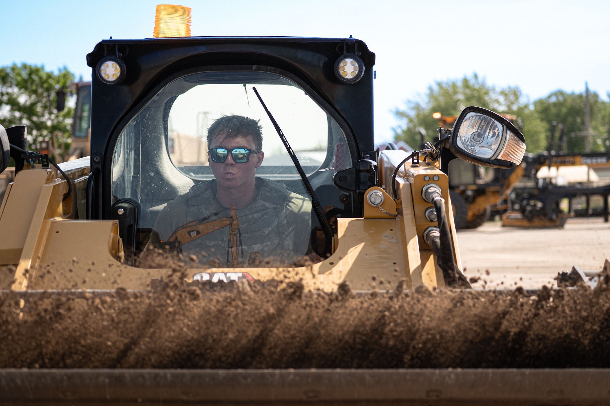 Senior Airman Mathew Plummer, pavements and equipment journeyman, 5th Civil Engineering squadron operates a compact tract loader, while repairing a crater during the bivouac exercise at Fargo Air National Guard Base, North Dakota, June 2nd, 2026. The objective of the crater repair exercise is to rapidly fix bombed-out runways so aircraft can continue to land and launch under pressure.