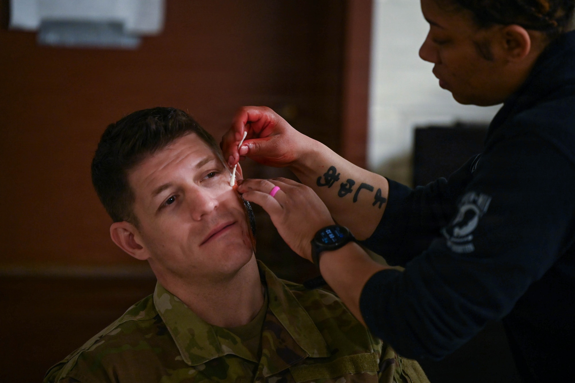 Jada Hunter, a member of the United States Air Force School of Aerospace Medicine, applies moulage to an airman from the 178th Wing during a Tactical Combat Casualty Care exercise in Springfield, Ohio, April 12, 2026. The simulated wounds challenged 178th Wing personnel to assess and treat injuries under conditions mirroring a real-world mass casualty event. (U.S. Air National Guard photo by Senior Airman Josh Kaeser)