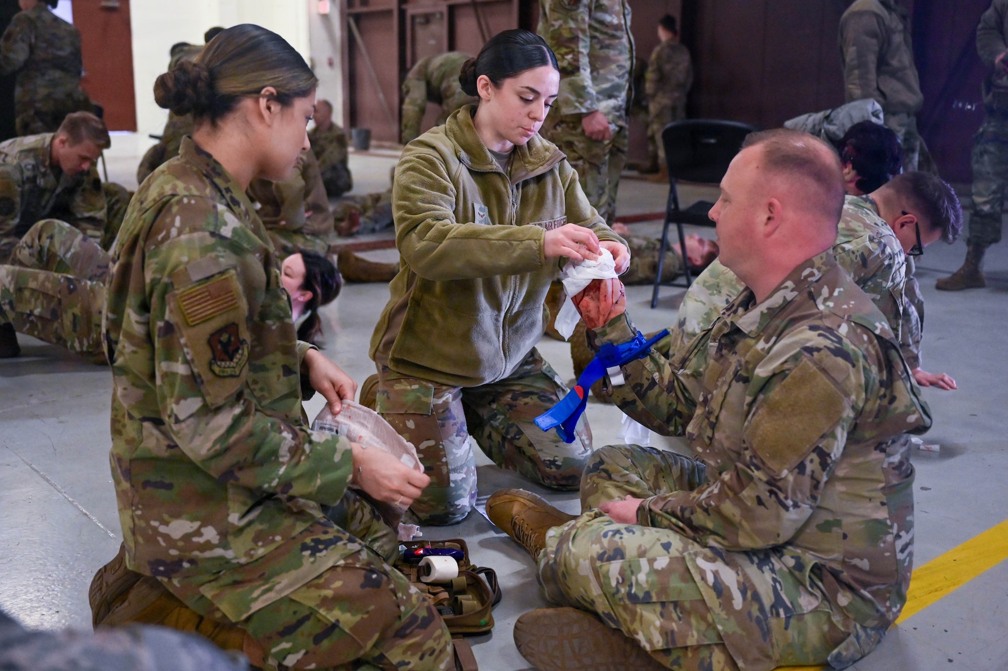 Airmen from the 178th Wing treat simulated injuries during a Tactical Combat Casualty Care exercise in Springfield, Ohio, April 12, 2026. The moulage, applied by members of the United States Air Force School of Aerospace Medicine, challenged personnel to assess and treat casualties under conditions mirroring a real-world natural disaster event. (U.S. Air National Guard photo by Senior Airman Josh Kaeser)