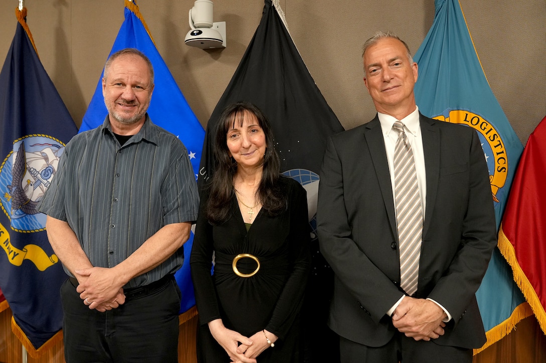 Three people pose for a photo after their retirement ceremony