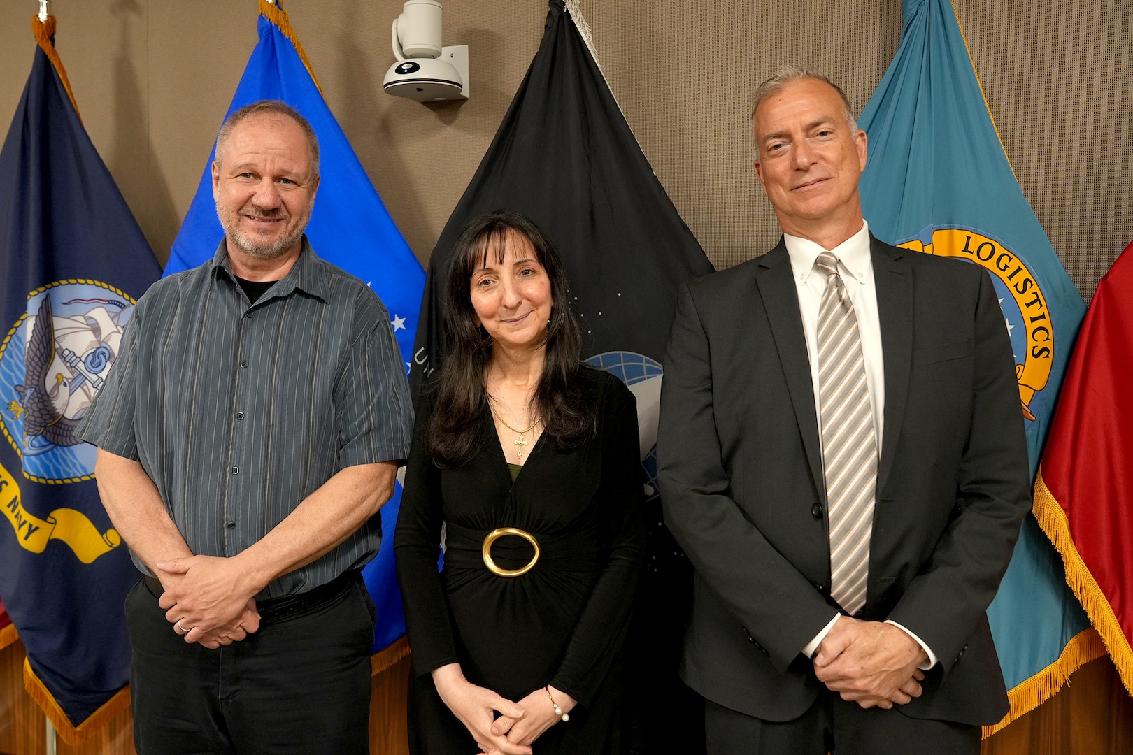 Three people pose for a photo after their retirement ceremony