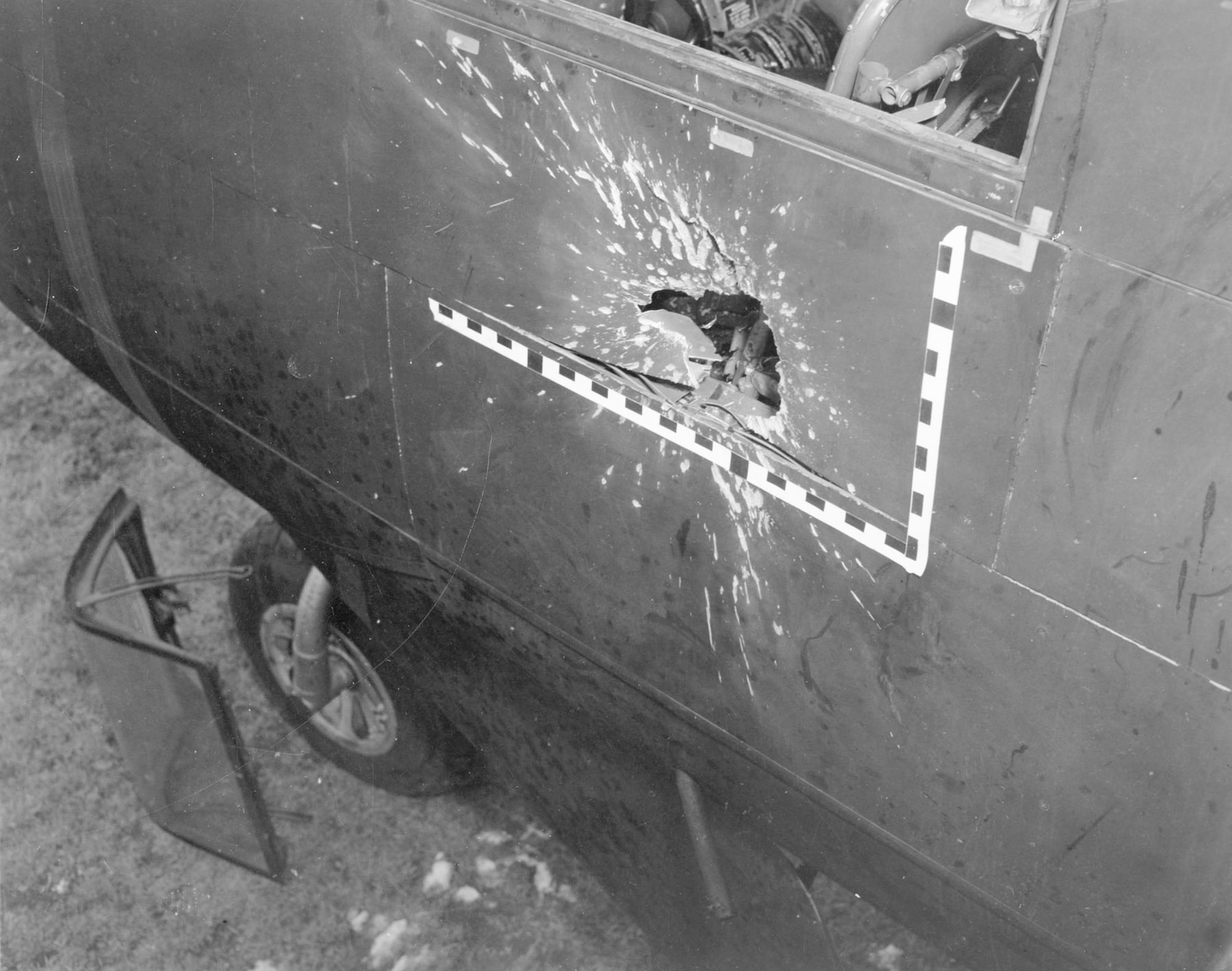 This historical photo shows the external battle damage to a B-26 Invader from an anti-aircraft shell on Dec. 8, 1952. The shell penetrated the cockpit, severely wounding the pilot and sending the aircraft into a dive before Tech. Sgt. James H. Ledford, the flight engineer, seized the controls and saved the crew. (U.S. Air Force photo)
