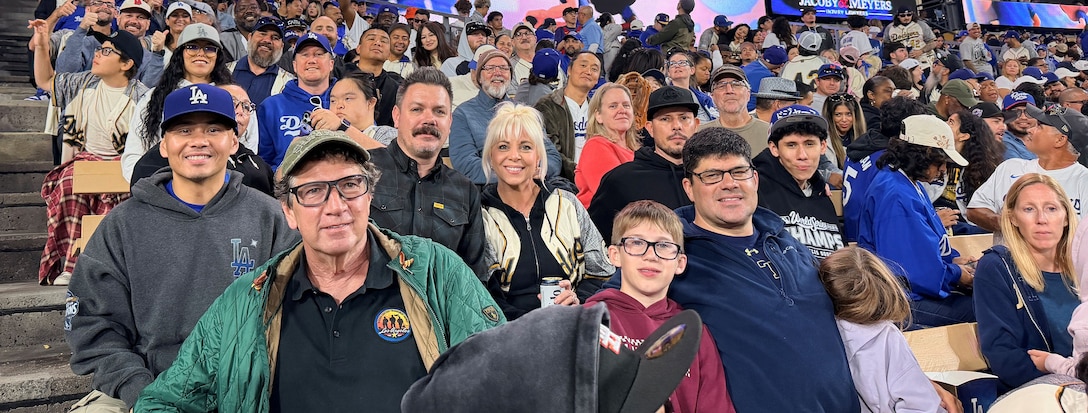 A group of fans in the stands at an LA Dodgers baseball game.