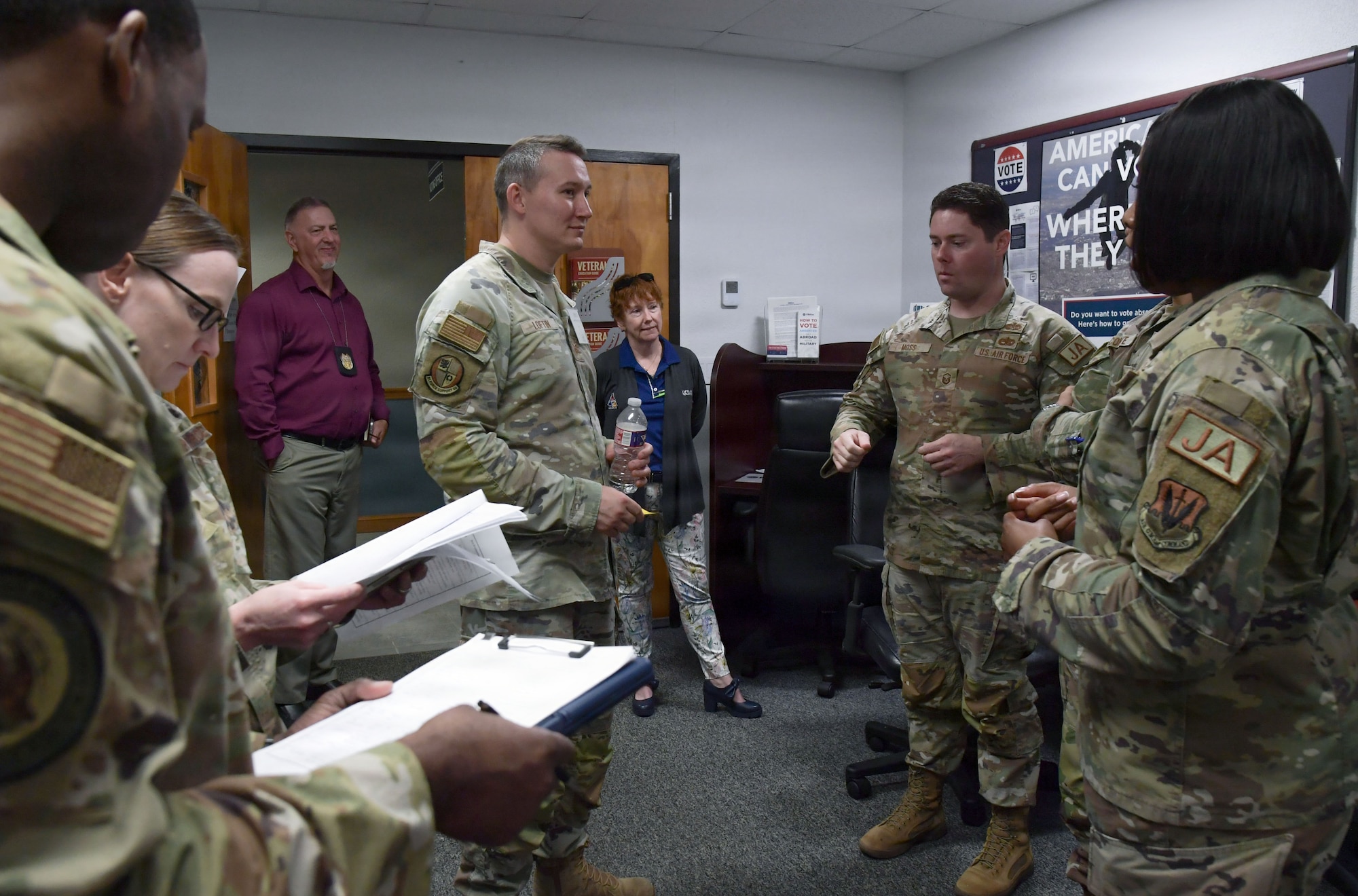 A group of U.S. Airmen speak to each other in a huddle.