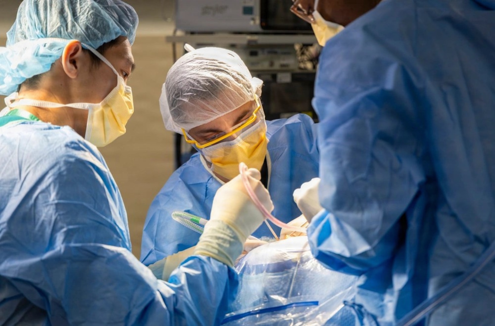 Surgeons in scrubs and masks operating on patient.
