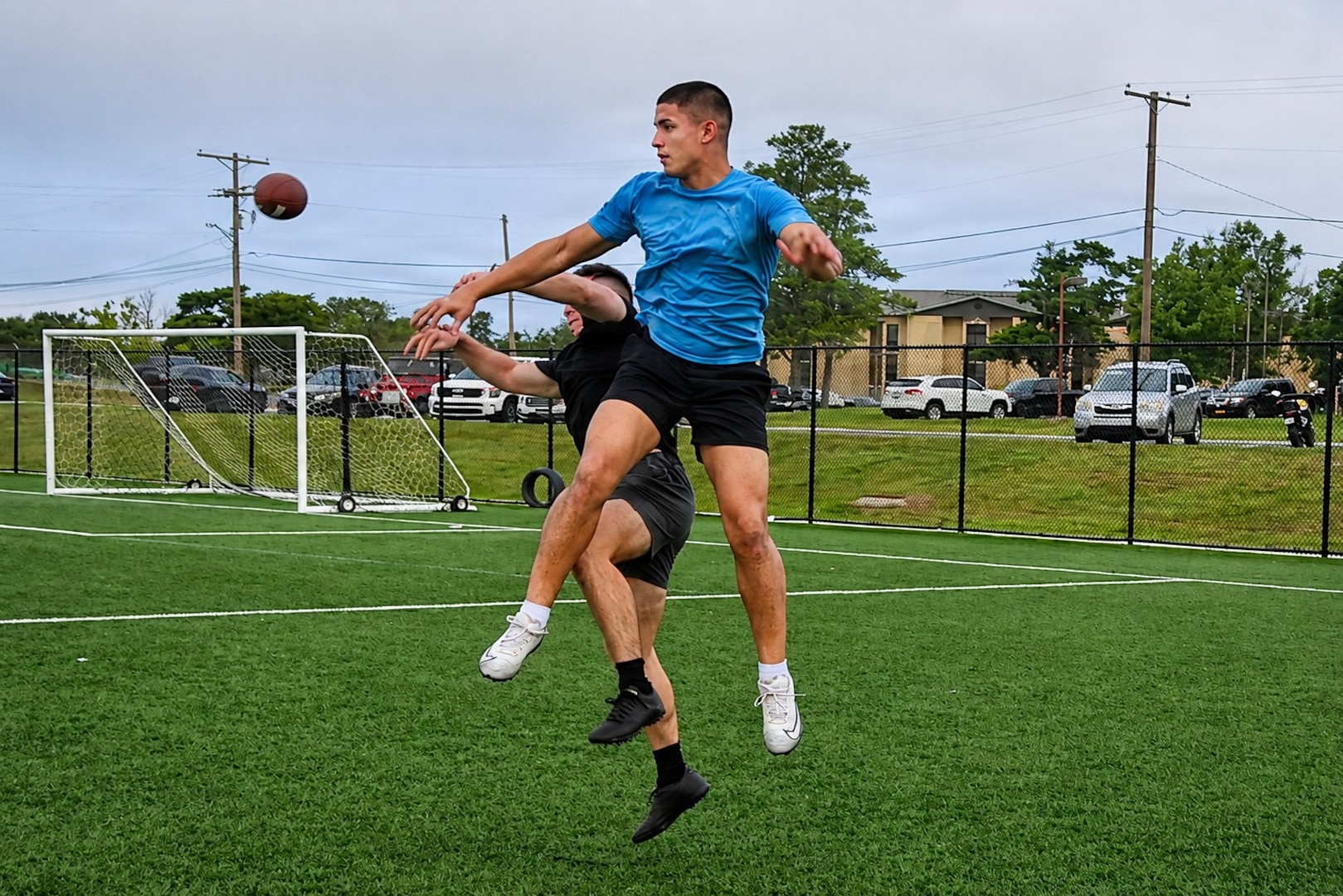 Two Soldiers in sports wear fight for a reception during a football game on Anvil Field.