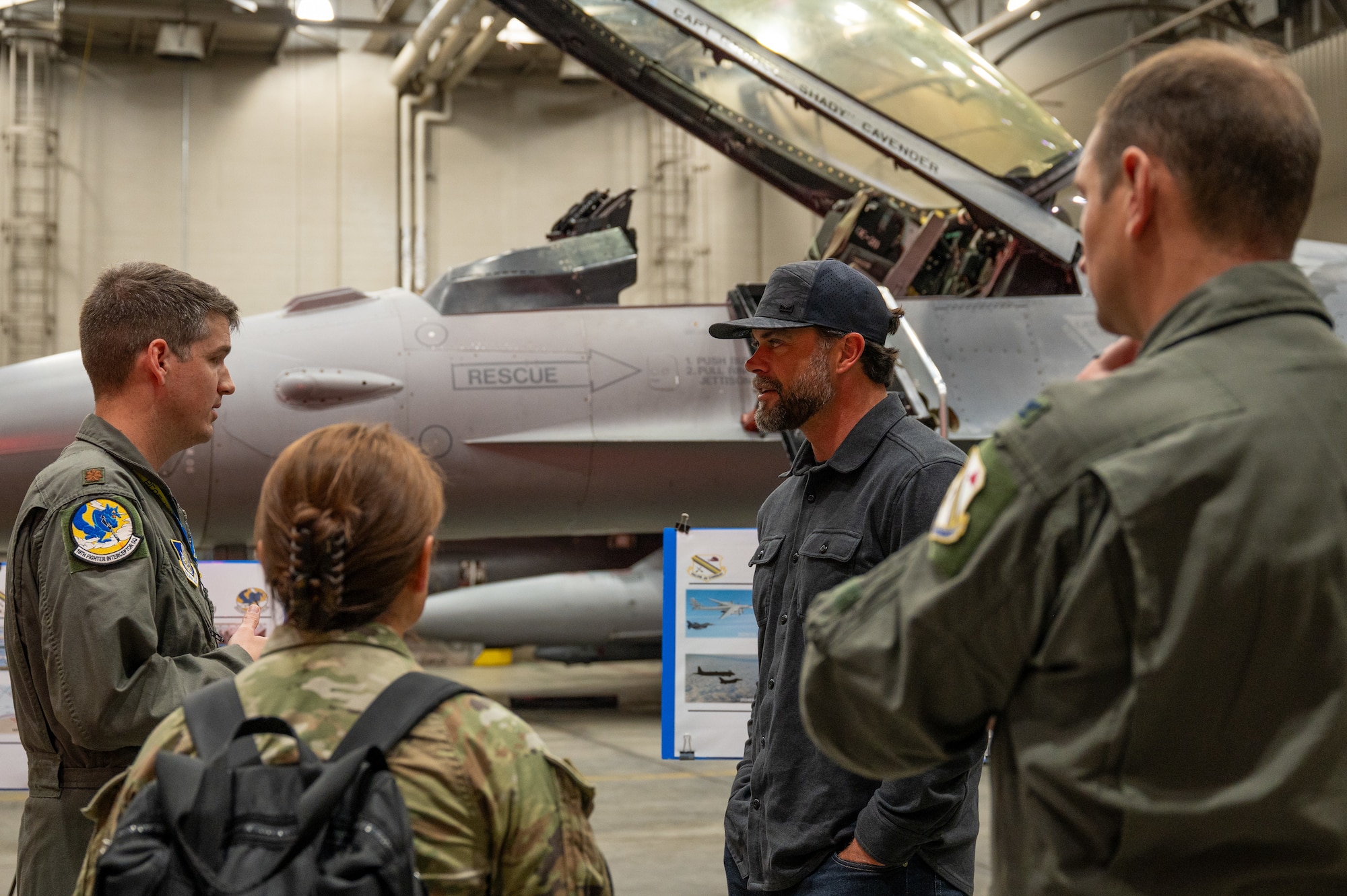 U.S Air Force Maj. Harrison Gebs, 18th Fighter Interceptor Squadron commander, left, briefs the Under Secretary of the Air Force Matt Lohmeier, right, during a tour at Eielson Air Force Base, Alaska, June 23, 2026.