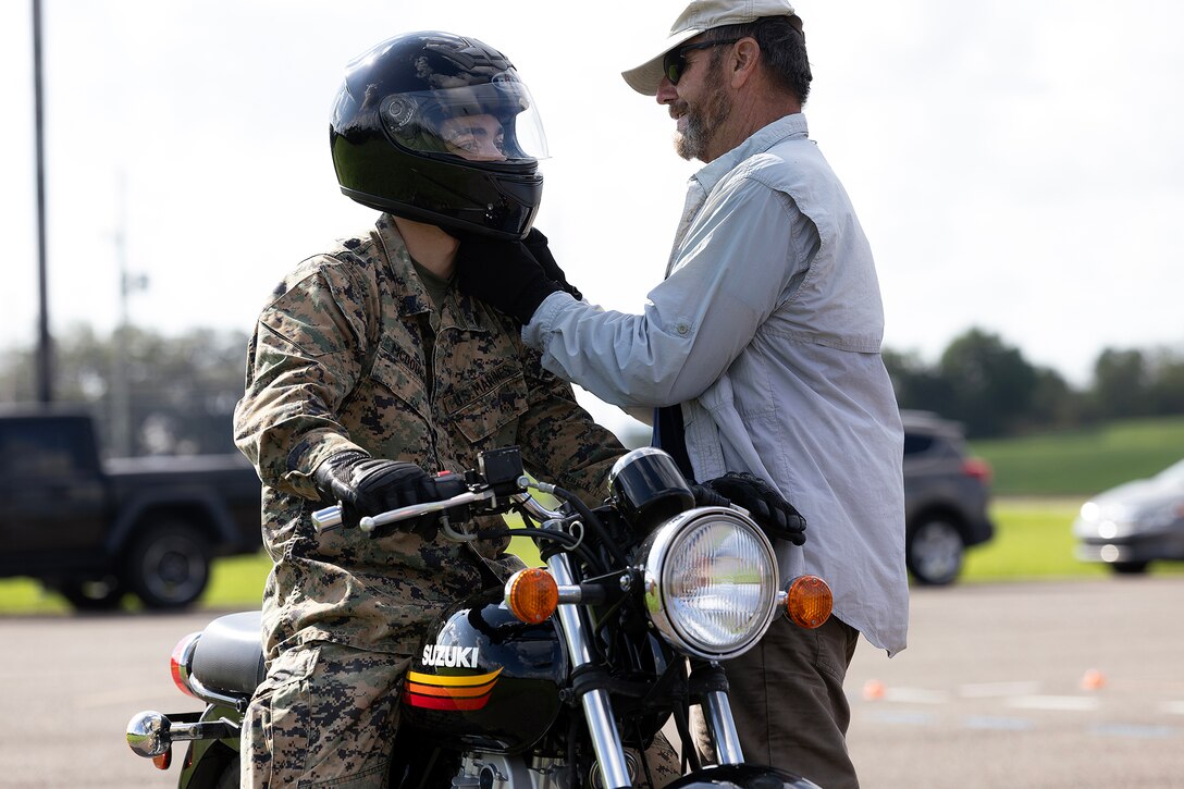U.S. Marine Corps Sgt. Bryan McDougal, a supply quality assurance specialist for Blount Island Command, prepares for a riding exercise as retired Navy Chief Warrant Officer 4 Greg Wojciechowski, a Motorcycle Safety Foundation rider coach, checks his helmet chin strap during a basic rider course June 25, 2026, at Marine Corps Support Facility Blount Island, Florida. The two-day course equipped novice riders with classroom instruction and hands-on training to develop rider proficiency and promote motorcycle safety. (Marine Corps photo by Dustin Senger)