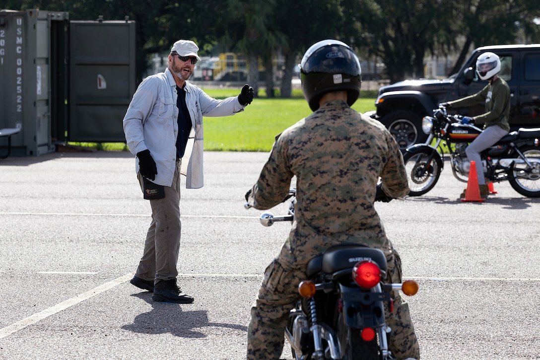Retired U.S. Navy Chief Warrant Officer 4 Greg Wojciechowski, a Motorcycle Safety Foundation rider coach, directs Sgt. Bryan McDougal, a supply quality assurance specialist for Blount Island Command, during a riding exercise in a basic rider course June 25, 2026, at Marine Corps Support Facility Blount Island, Fla. The two-day course equipped novice riders with classroom instruction and hands-on training to develop rider proficiency and promote motorcycle safety. (Marine Corps photo by Dustin Senger)