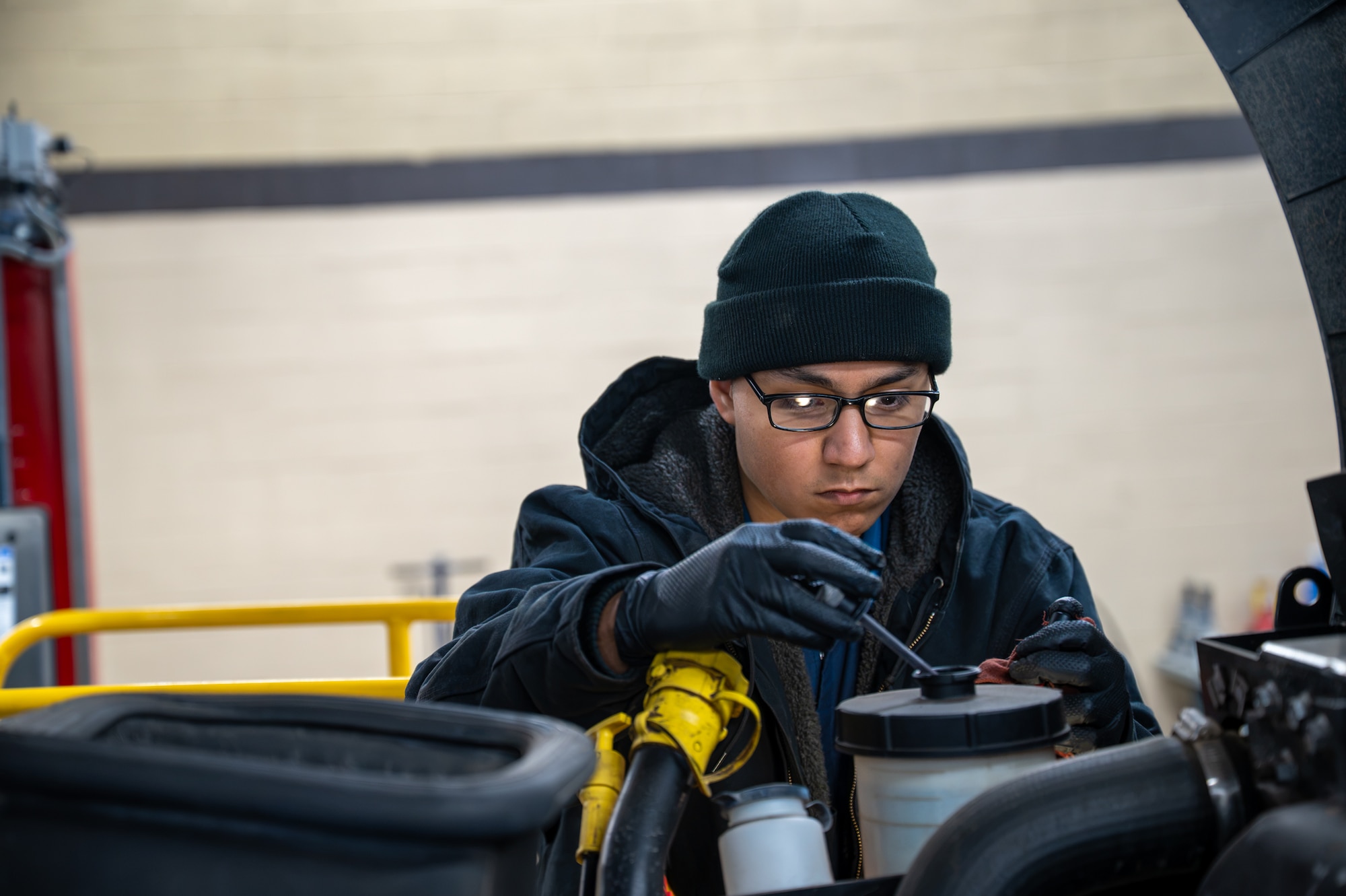 A man performs maintenance on a vehicle.