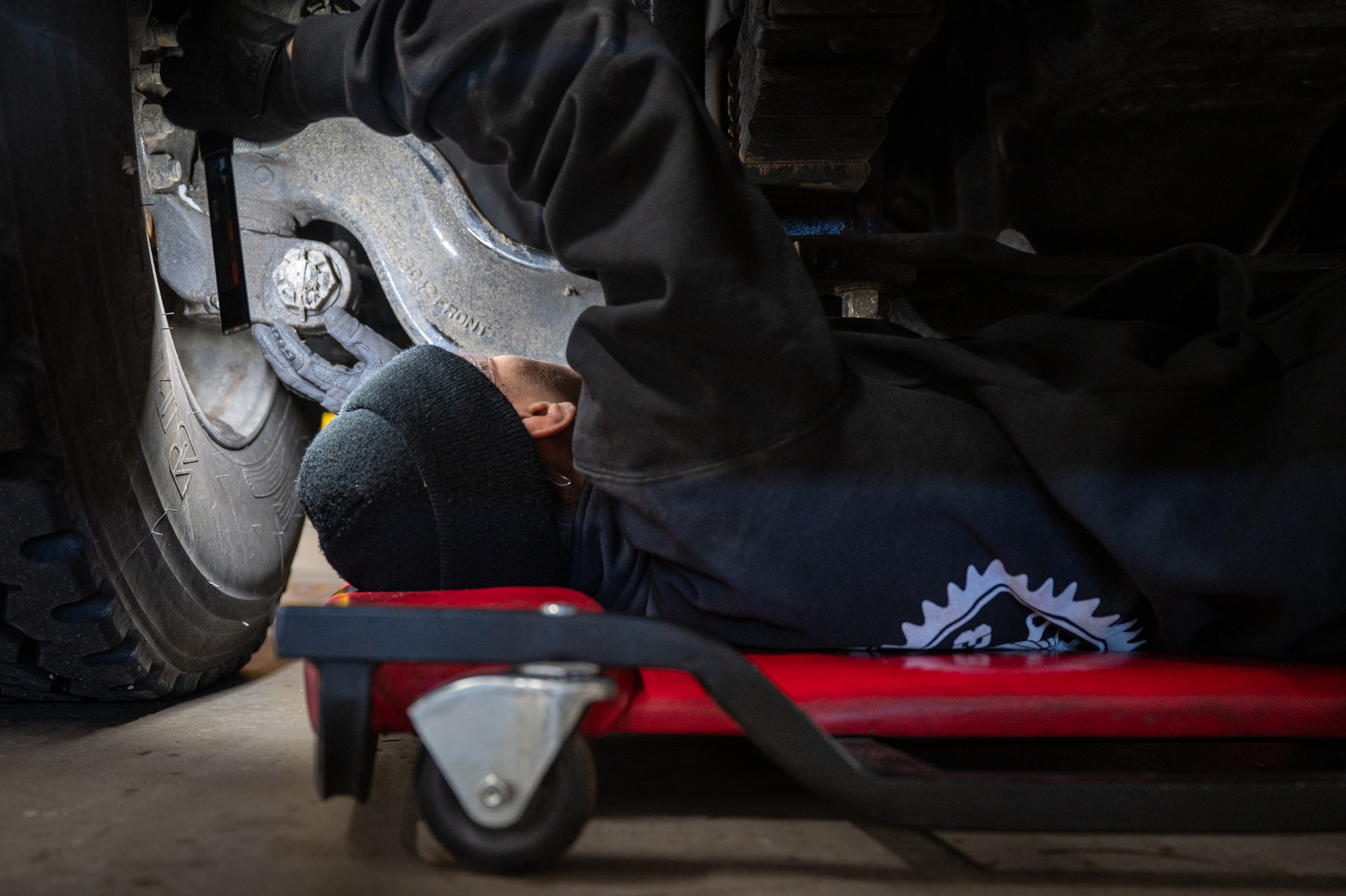 A man does maintenance on a vehicle.
