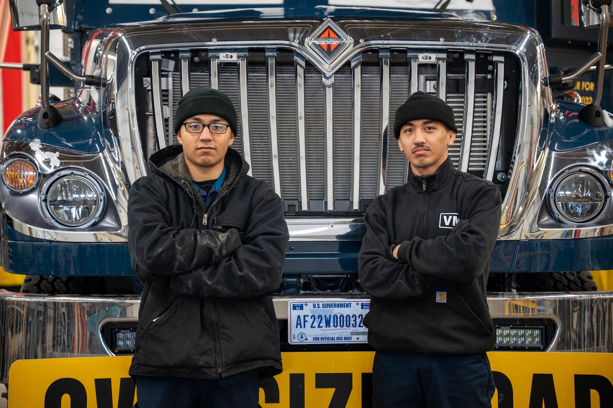 Two men pose for a photo in front of a Payload Transporter Replacement.