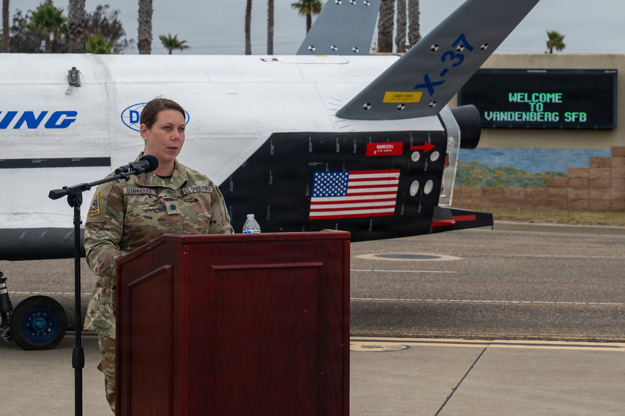 A person stands and speaks behind a podium