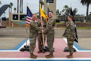 Four people stand and two of the people hold a flag