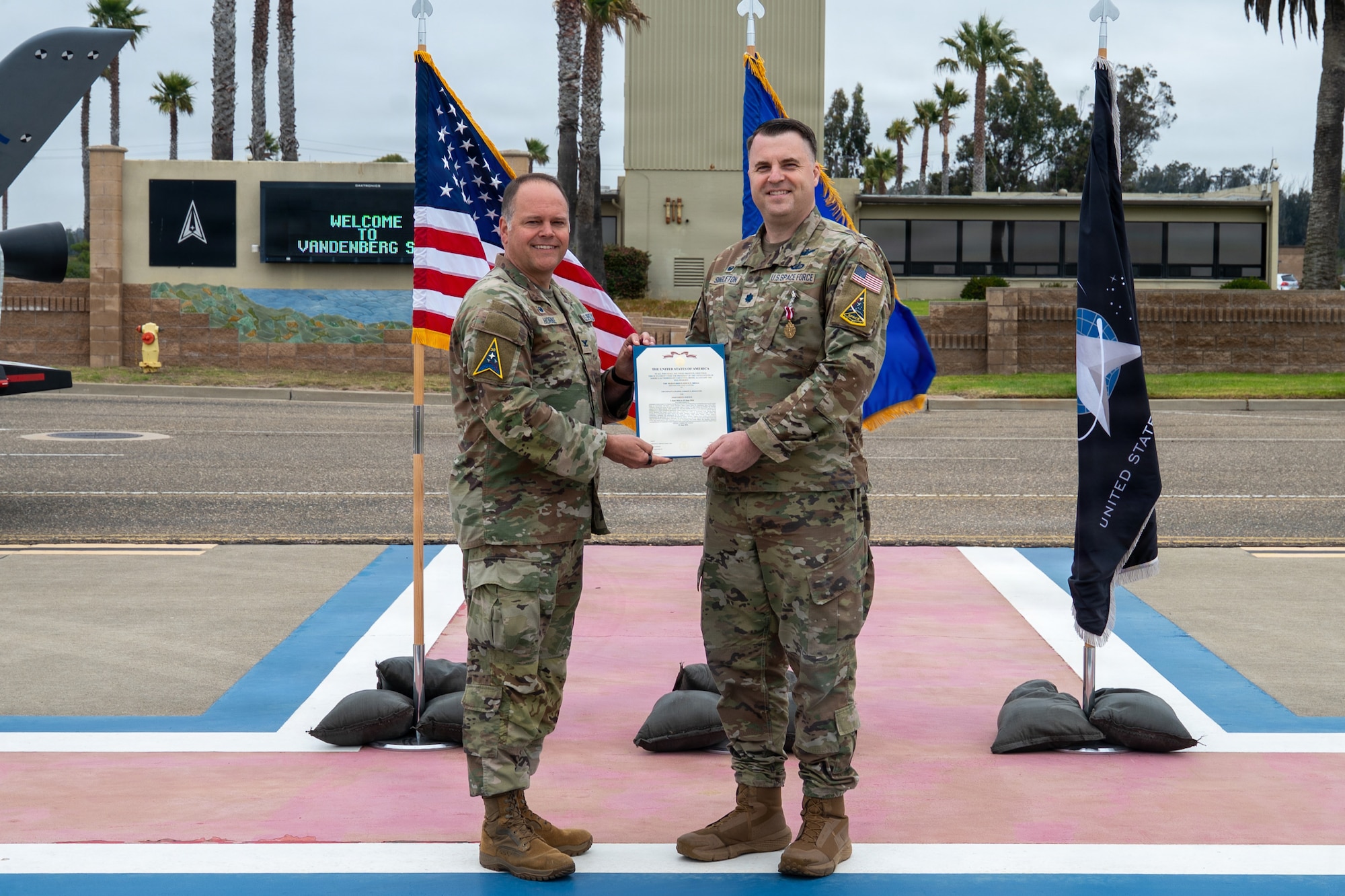 Two people stand and hold a certificate