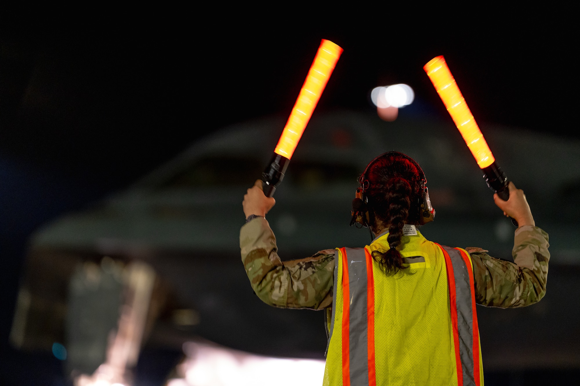 A U.S. Air Force crew chief assigned to the 393rd Expeditionary Bomb Squadron marshals a B-2 Spirit aircraft during a Bomber Task Force deployment at Royal Australian Air Force Base Amberley, Queensland, Australia, June 11, 2026.