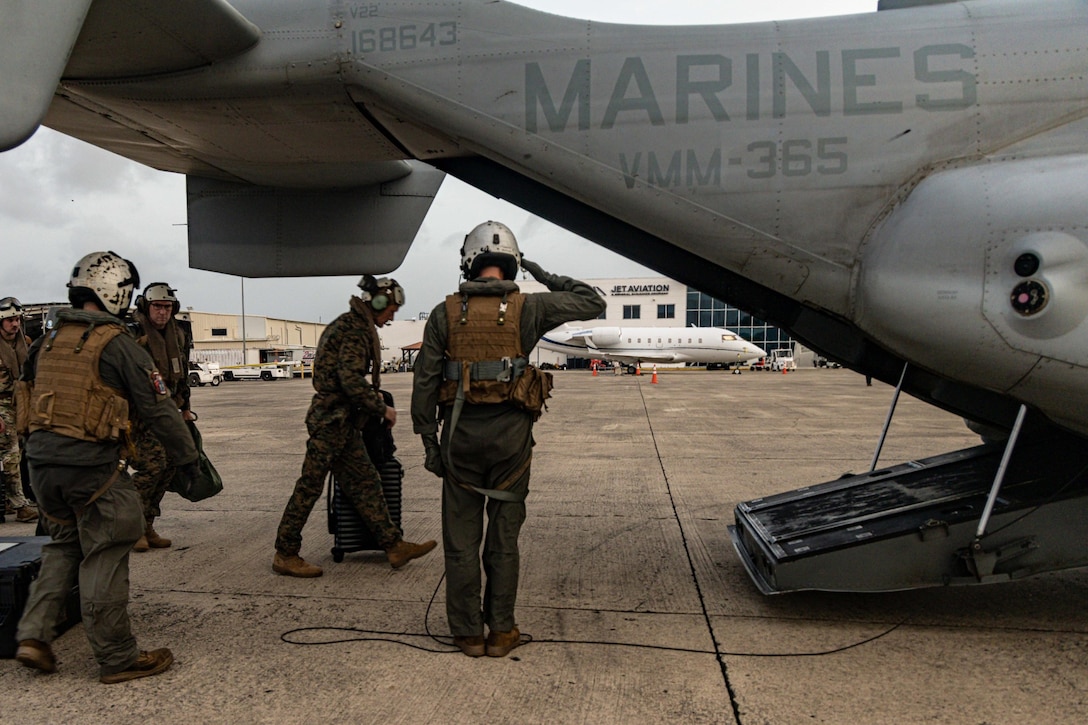 A military person boards a military aircraft.