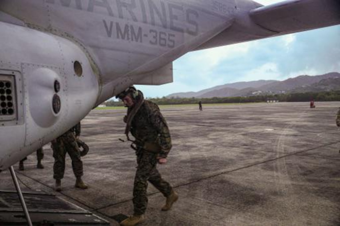 A military person boards a military aircraft.