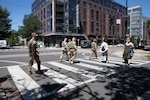National Guardsmen cross the street while on patrol in Washington as part of the D.C. Safe and Beautiful Task Force, June 20, 2026.
