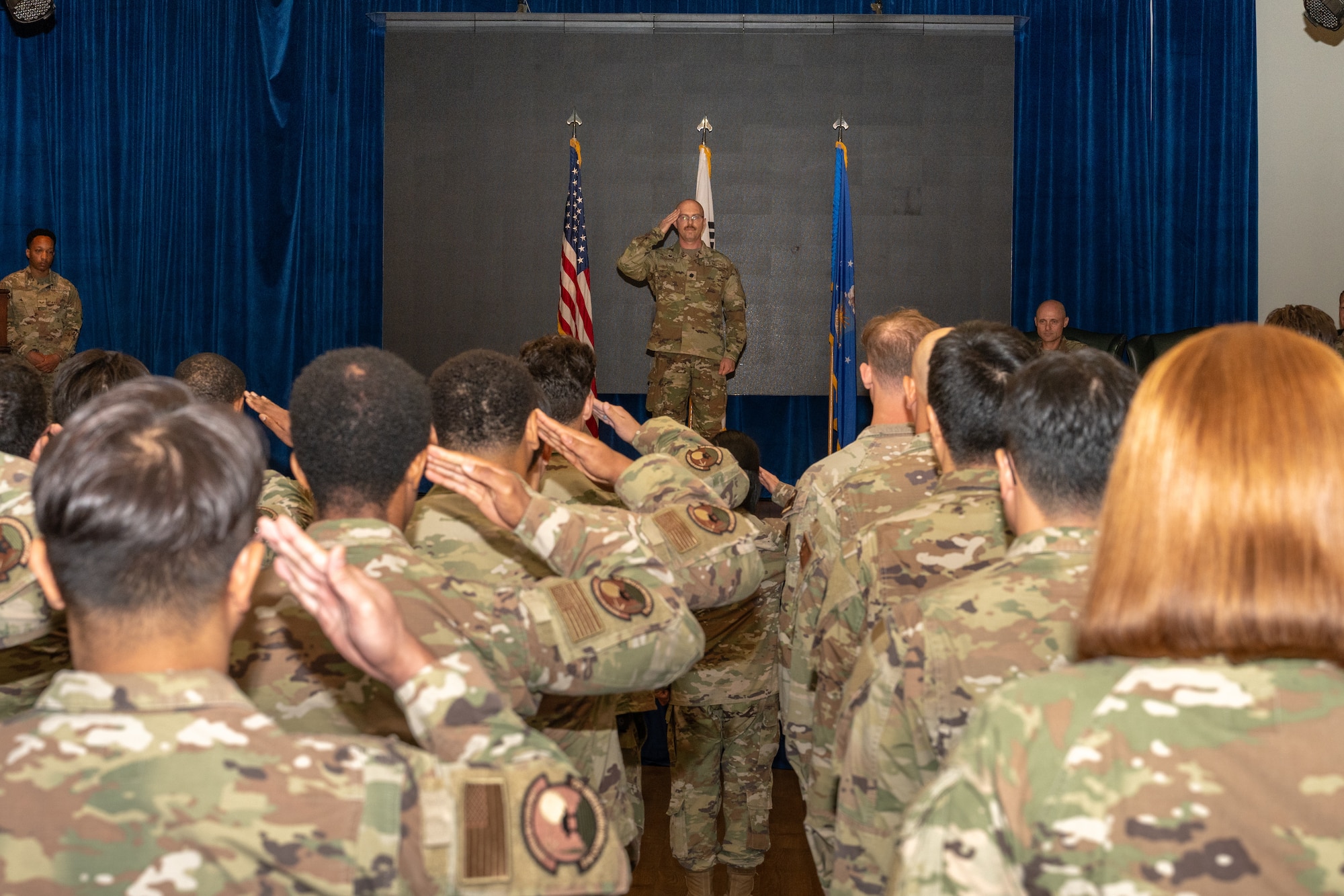 A new commander salutes squadron members after a ceremony.