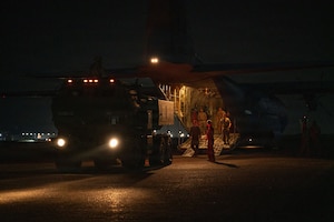 A military vehicle backs into an aircraft