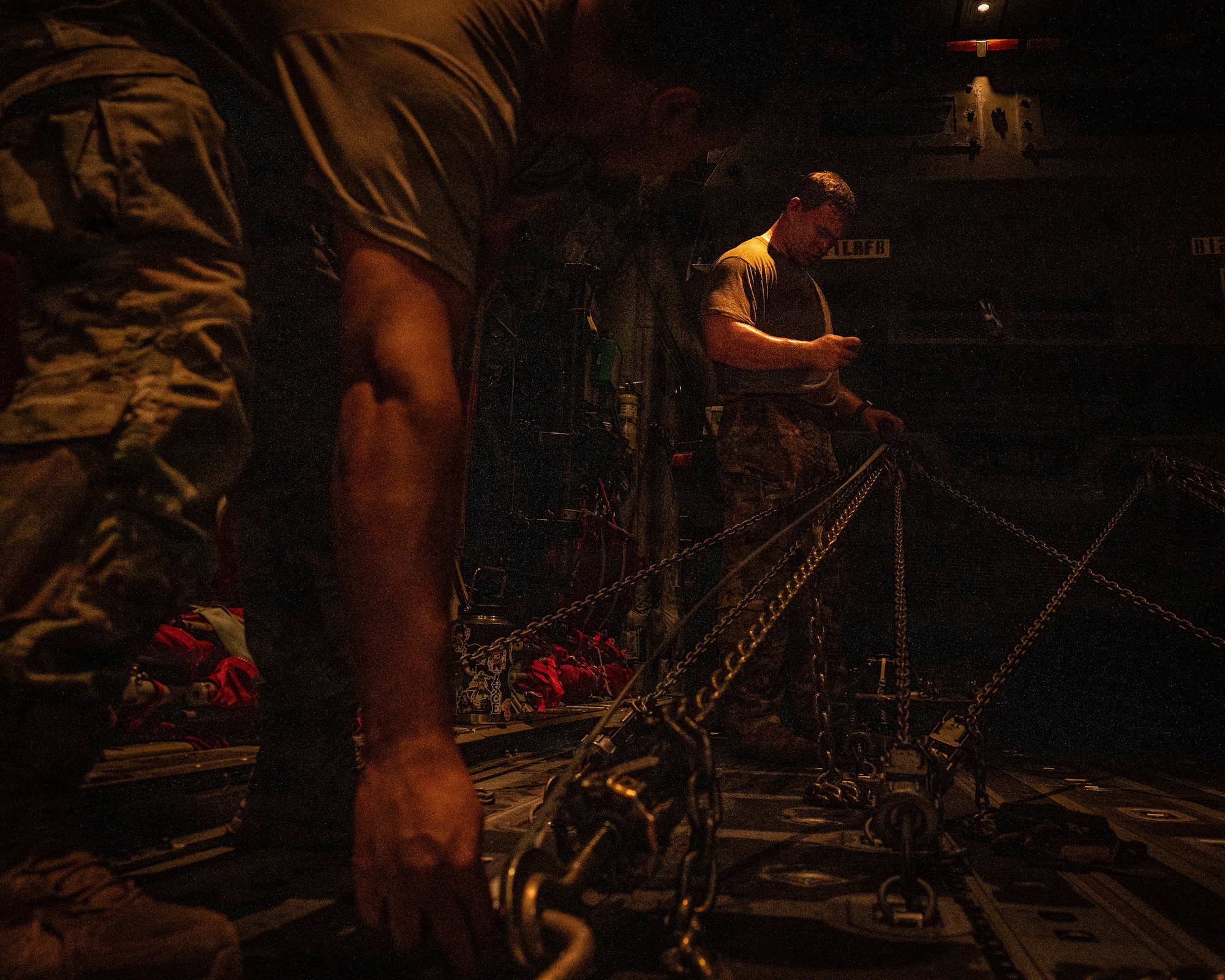 Servicemembers strap down a military vehicle
