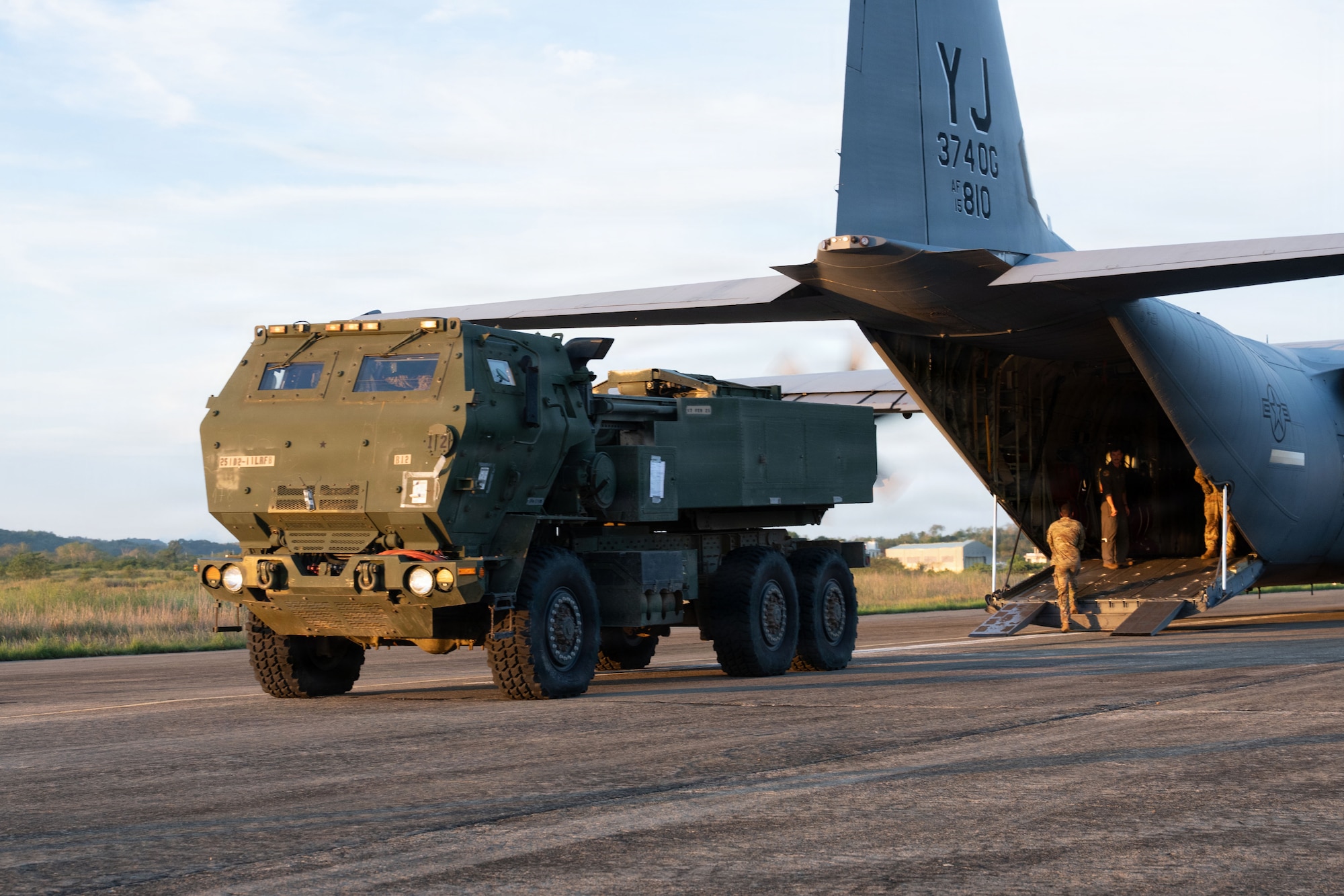 A military vehicle prepares to back into an aircraft