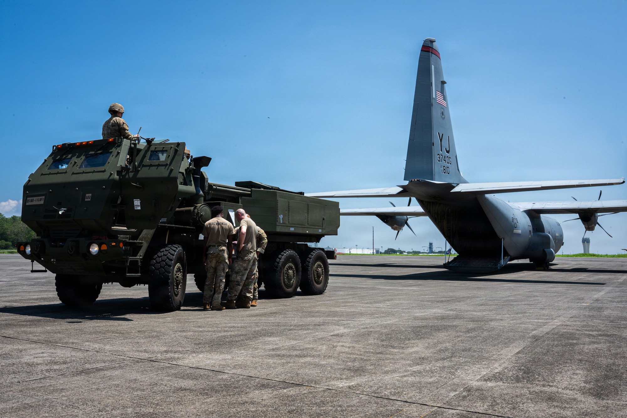 A military vehicle prepares to back into an aircraft