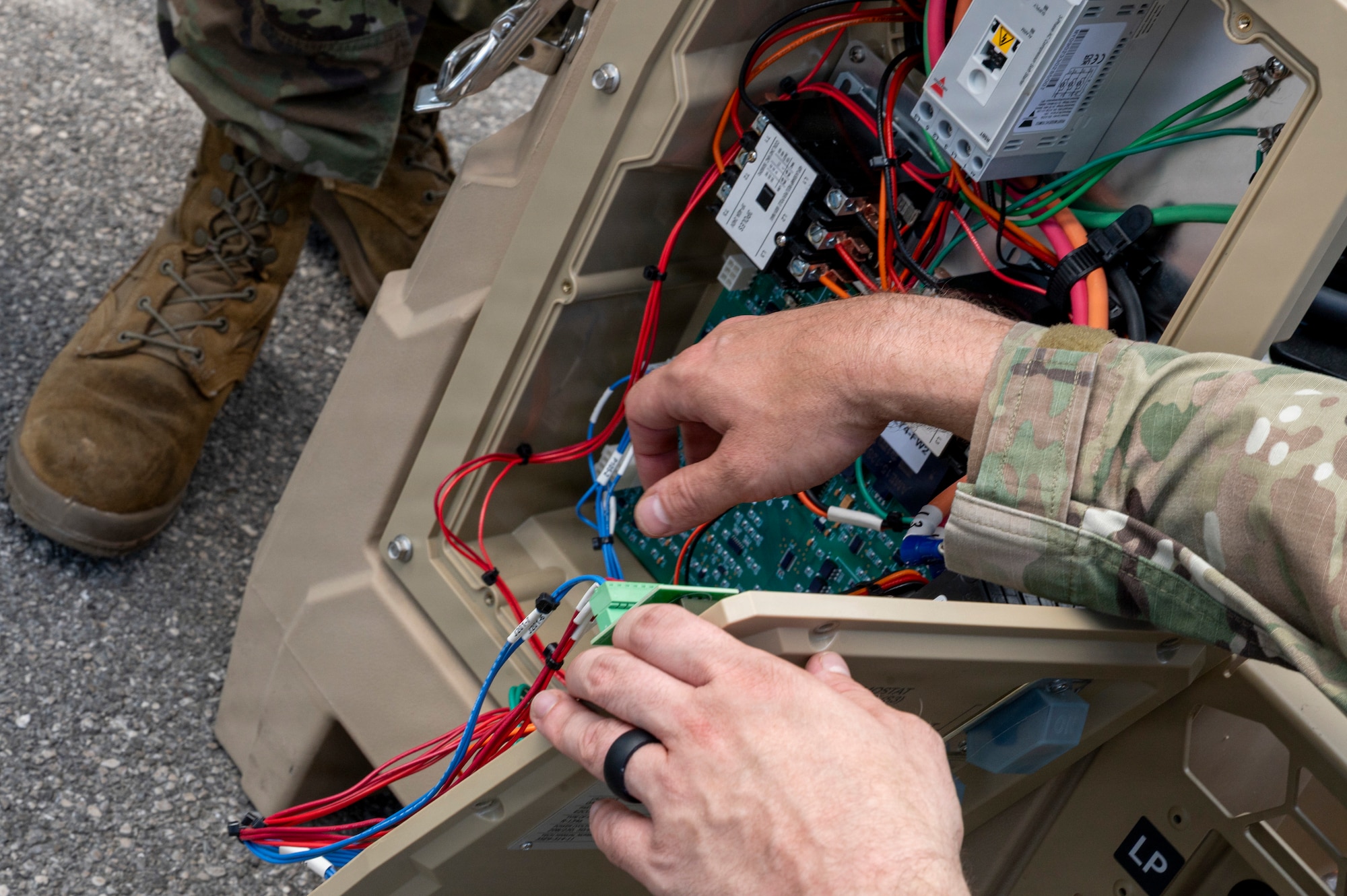 A man displays internal electrical components on an HVAC system.