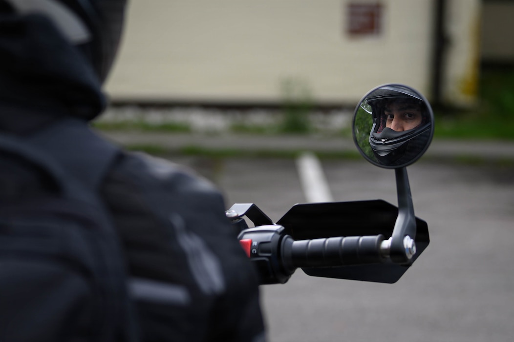 Man on a motorcycle looking in mirror.