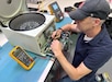 A biomedical equipment technician works on a piece of medical equipment.