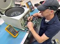 A biomedical equipment technician works on a piece of medical equipment.