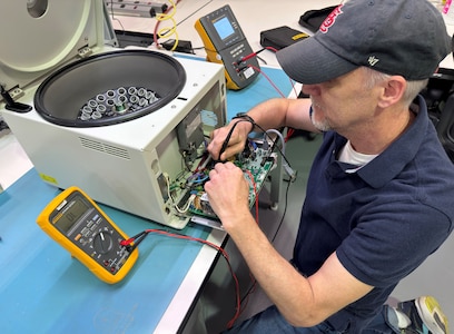 A biomedical equipment technician works on a piece of medical equipment.