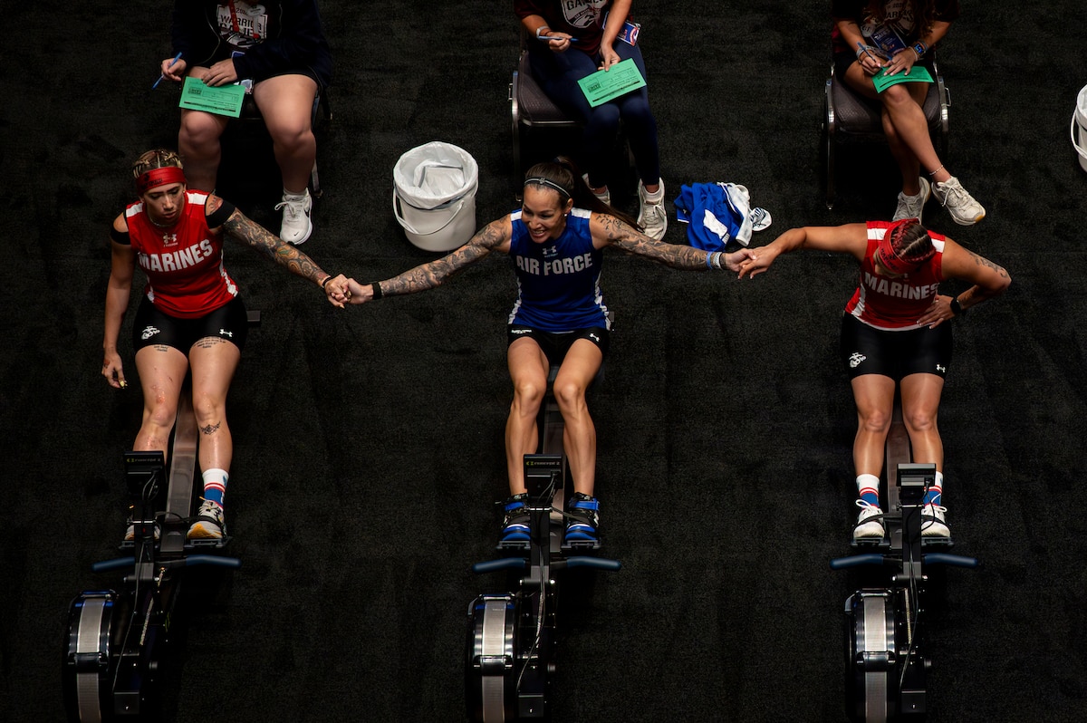 U.S. Marine Corps Cpl. Giavanna Vicario (left), U.S. Air Force Chief Master Sgt. Nicole Favuzza (center), and U.S. Marine Corps Maj. Kim Yen Soto (right) prepare to compete in the indoor rowing competition during the Warrior Games, San Antonio, Texas, June 18, 2026. The Warrior Games celebrate the determination, strength, and resilience of wounded, ill, and injured service members and veterans. The 2026 Warrior Games take place 13-20 June in San Antonio, Texas, bringing together nearly 200 wounded, ill, and injured service members and veterans from the Army, Marine Corps, Navy/Coast Guard, Air Force/Space Force, and Special Operations Command to compete across multiple adaptive sporting events. (U.S. Air Force Photo by Tech. Sgt. Shawn White)