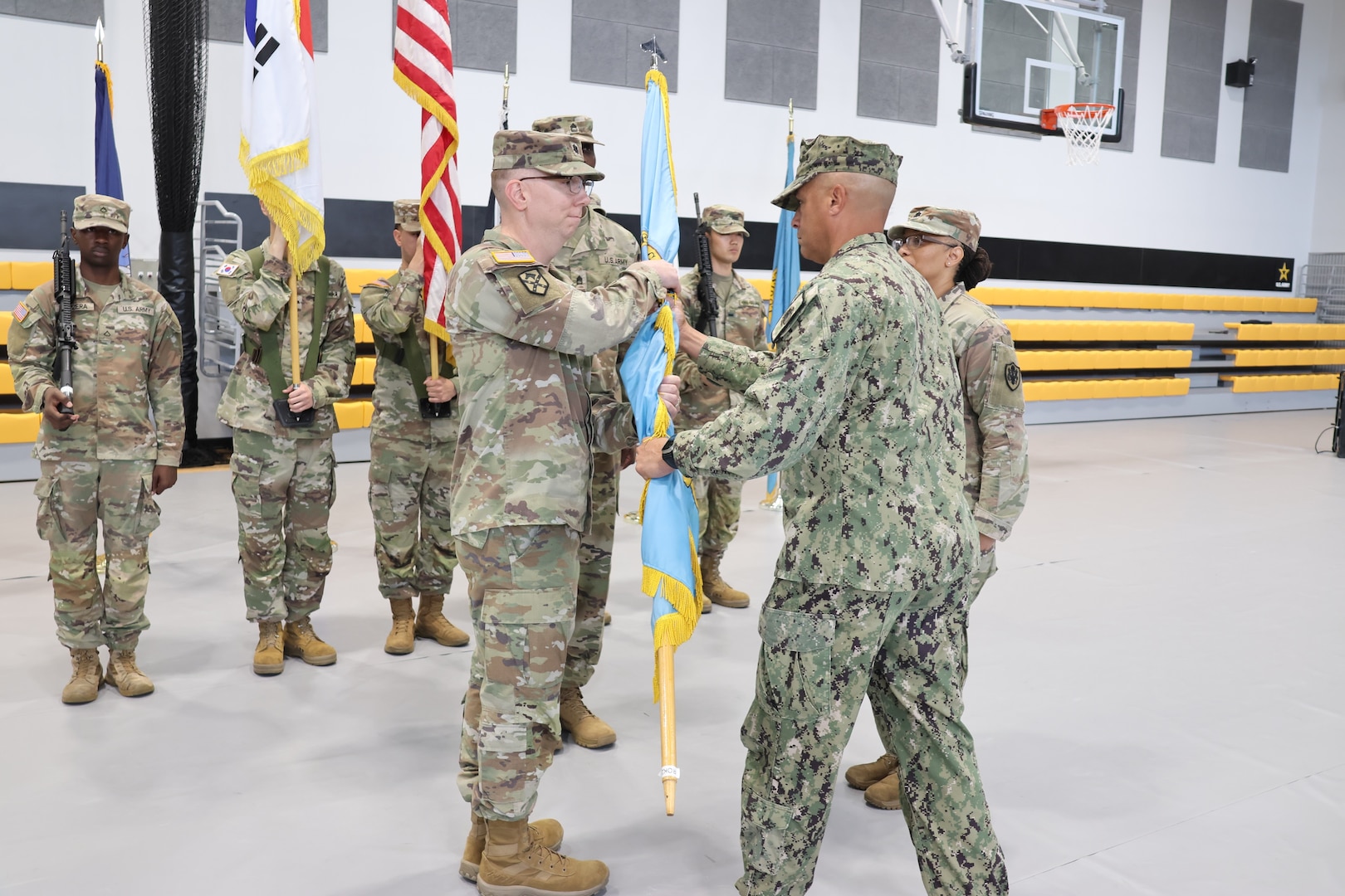 A unit guidon is passed from one person to the other.