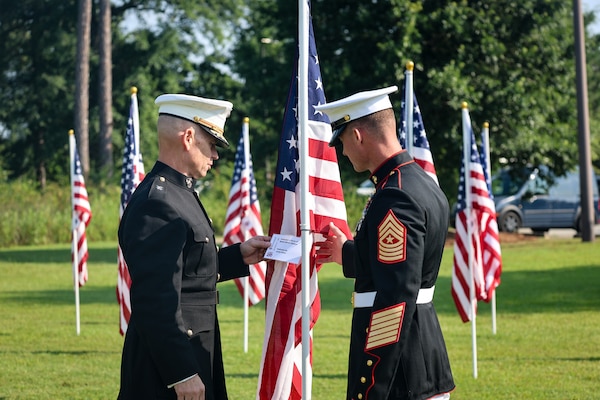 Maj. Gen. Keith D. Reventlow, commanding general, Marine Corps Logistics Command, and Sgt. Maj. Marshall H. Gregg, senior enlisted advisor, MARCORLOGCOM, view one of the dedicated flags displayed on the Exchange Club of Lee County’s Field of Honor after the opening ceremony at the Oakland Library in Leesburg, Georgia, June 26, 2026. The display honors service members, veterans and the sacrifices represented by the American flag.
