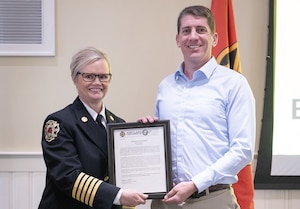 Chief of Portland Fire and Rescue Lauren Johnson (Left) hands Senior Airman Joshua Mayer the Certificate of Merit at a ceremony in Portland, Ore. on June 2, 2026. Mayer was lauded for his life saving efforts after a vehicle accident in 2025. (Photo courtesy of Portland Fire and Rescue)
