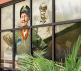 A mural commemorating the anniversary of the Berlin Airlift displays on a window of a building.