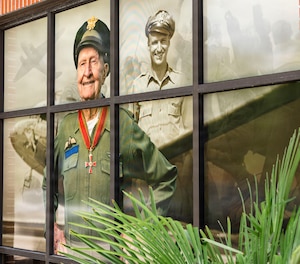 A mural commemorating the anniversary of the Berlin Airlift displays on a window of a building.
