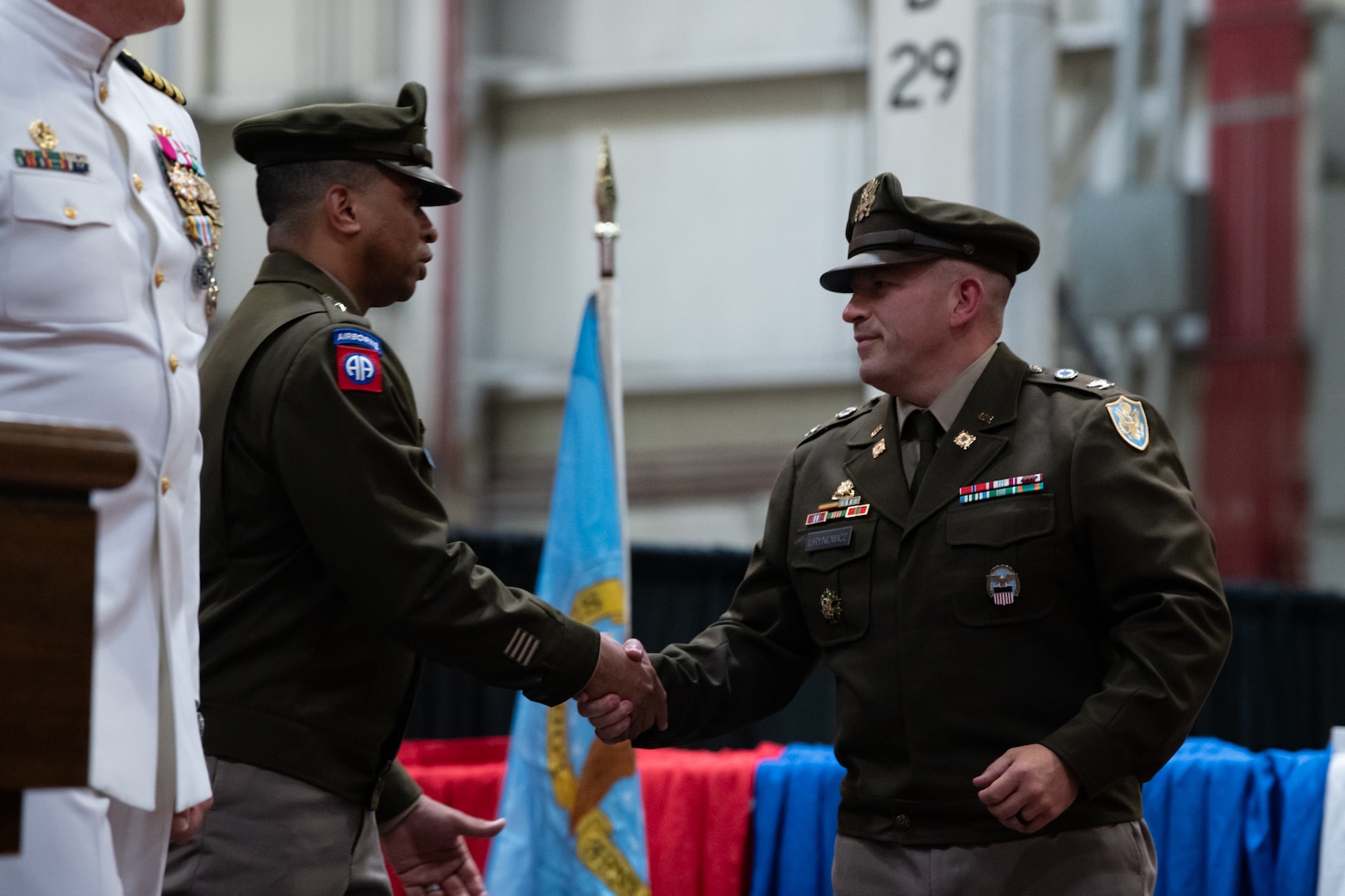 Two men in military uniforms shake hands