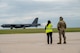 Two people watch an aircraft land.