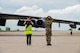 Two people guide an aircraft in.