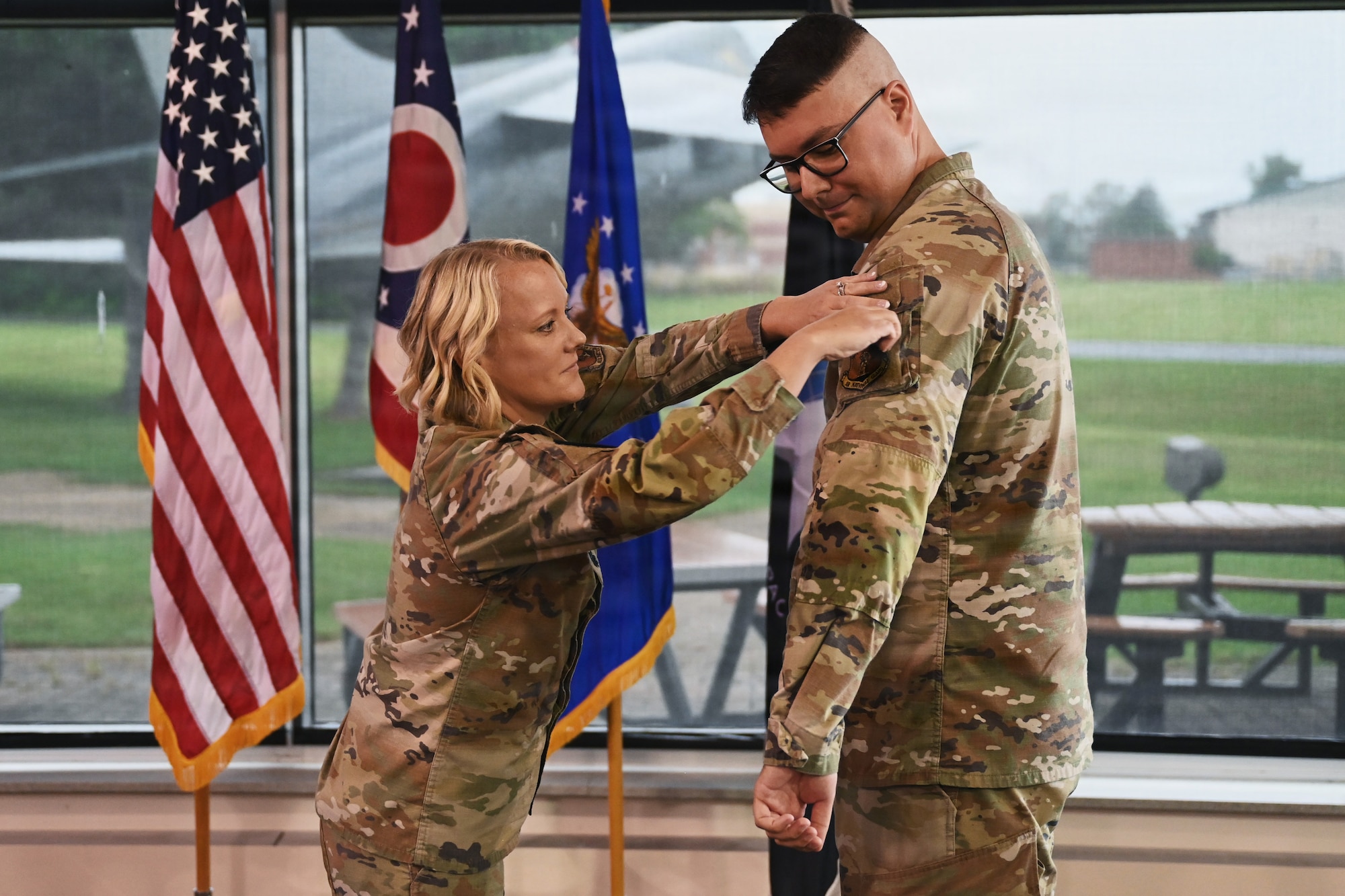 U.S. Air Force Lt. Col. Britney Hensley, commander of the 126th Intelligence Squadron, removes the 126th IS unit patch from Tech. Sgt. Dylan Jacques, an intelligence analyst assigned to the 126th IS at Springfield-Beckley Air National Guard Base, who transferred to the 76th Intelligence, Surveillance and Reconnaissance Squadron in a historic ceremony June 26, 2026. This marks the first time an Airman in the Air National Guard has been authorized to transfer to the Space Force without completing their existing service commitments to the Guard. (U.S. Air National Guard photo by Shane Hughes)